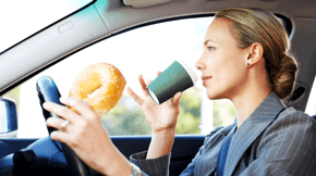 A driver eating and drinking while driving.